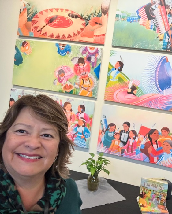 Photo of Andrea Page in front of the Powwow Day Art Wall