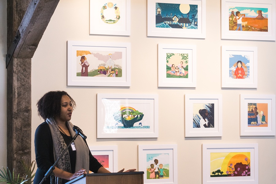 Photo of Shadra Strickland in front of her illustrations on the Boyds Mills Art Wall.